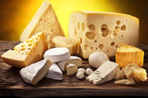 Different types of cheese over old wooden table.